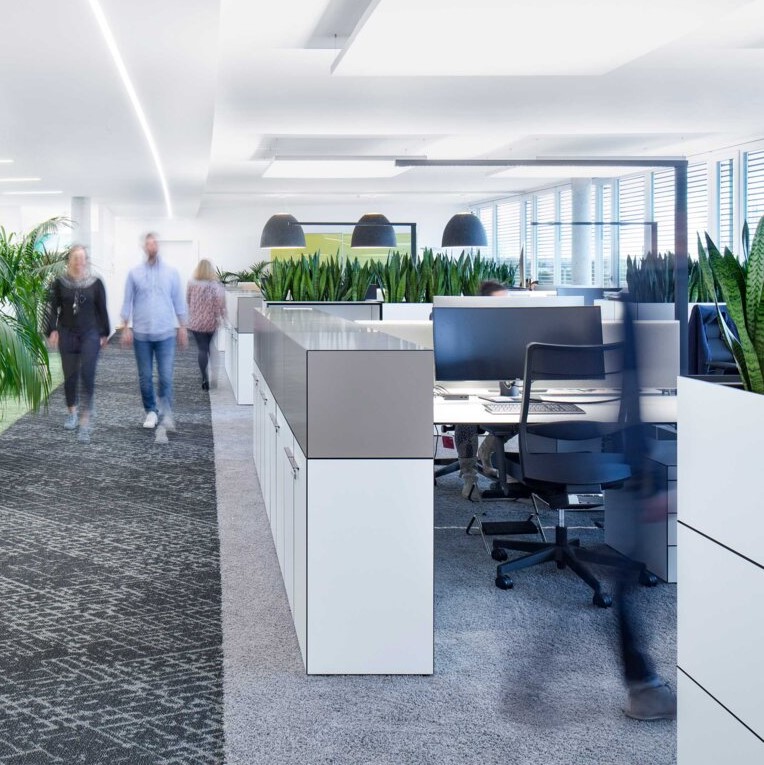 Open space in un ufficio con illuminazione LED efficiente che migliora il comfort visivo e l'atmosfera.